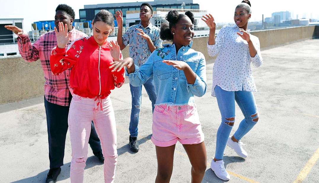 A imagem mostra um grupo de jovens com meninas e meninos dançando. 